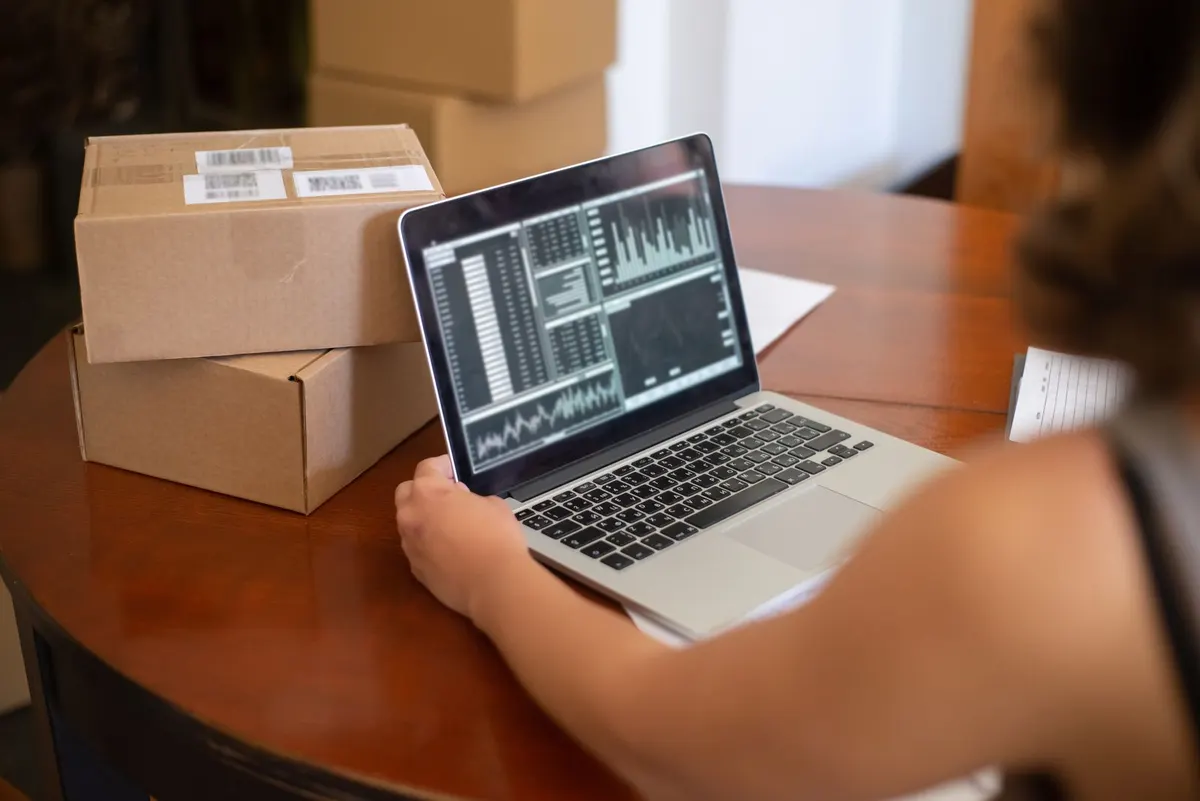 Vlasnica novog biznisa na laptopu pored paketa — sajt, SEO i AI automatizacija za mali biznis