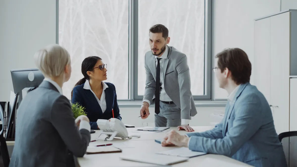 Team meeting discussing website cost in a modern office